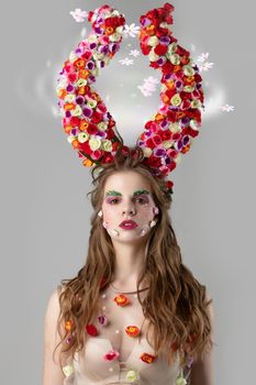 Beautiful girl with flower horns. Malificent. Spring beauty. Woman flower.Goddess of flowers Flora.