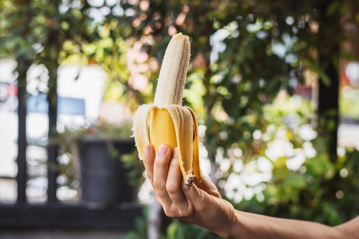 Closeup a woman's hand holding a ripe banana