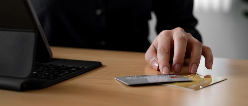 Close up hand of woman using credit card for online payment with smart teblet.