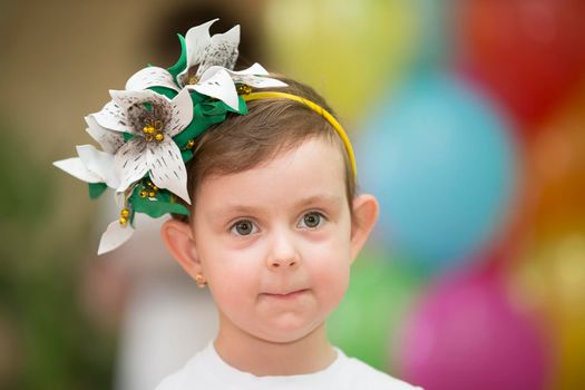 Belarus, the city of Gomil, May 30, 2019. Open day at kindergarten. Portrait of a funny girl. Little funny girl with lop-eared ears and a floral wreath on her head.