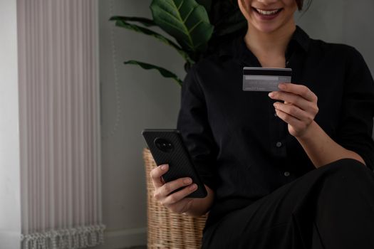 Asian girl making online payment using smartphone for shopping at home