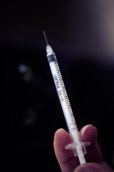 Insulin injecting syringe held by nurses hand. Copy space