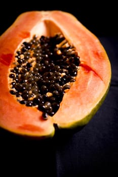 Half of an open papaya with the seeds. No people