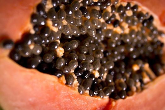 Half of an open papaya with the seeds. No people