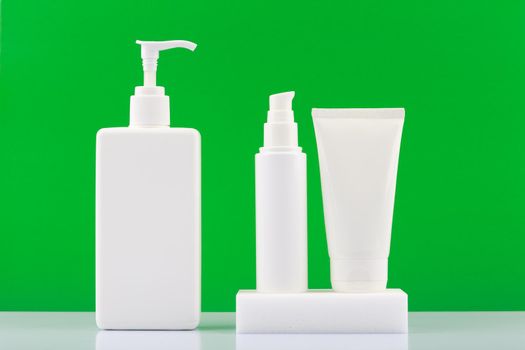 Set of cosmetic products with body cream, face cream and scrub against bright green background. Concept of natural organic cosmetic products for skin and body care