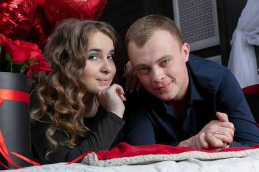 Portrait of a beautiful young couple. A man and a woman are lying on the floor. Lovers.