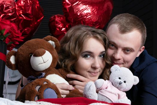 Boyfriend and girlfriend on Valentine's Day. Portrait of lovers. A man and a beautiful woman with flowers and bears.