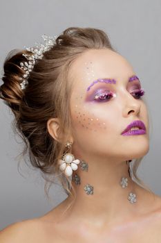 Model face with purple make-up. Beauty with unusual eyebrows. Beautiful girl portrait.