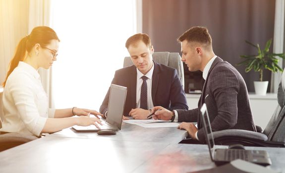 Group of young successful businessmen lawyers communicating together in a conference room while working on a project. 