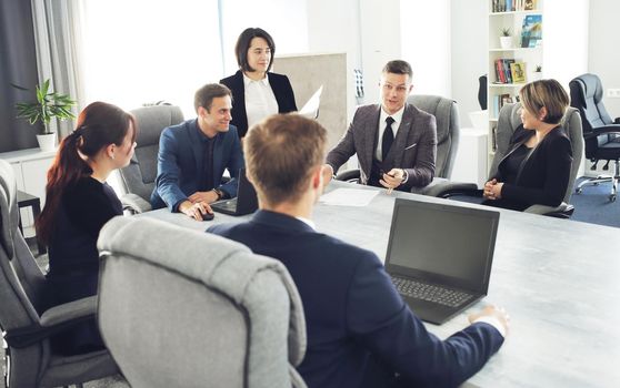 Group of young successful businessmen lawyers communicating together in a conference room while working on a project. 