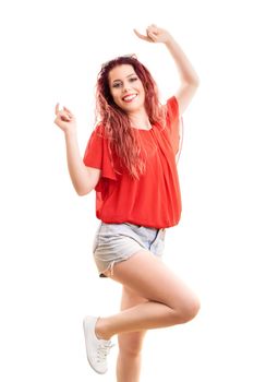 Beautiful redhead woman with long wavy hair in a fashionable summer outfit jumping out of happiness, isolated on white background. Summer, enjoying concept.