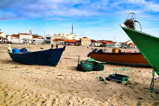 Colorful Fishing boats stranded on Aguda beach and little houses in the background