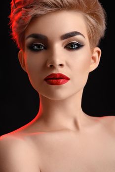 Red lipped girl. Vertical cropped portrait of a gorgeous elegant young woman with professional hairstyle and smoky eyes and red lips makeup posing confidently beauty skincare perfection flawless