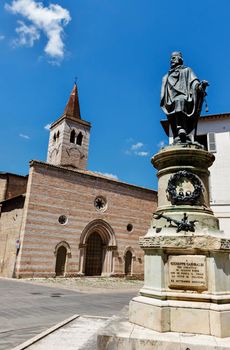 Foligno Piazza Garibaldi , church of San Salvatore facade with rows of red and white stones , in the foreground Garibaldi bronze figure by Ottaviani