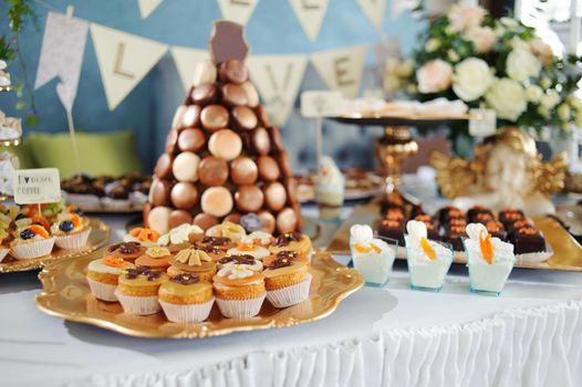 fruit tartlets on a golden tray, festive table with desserts.