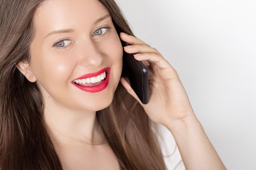 Happy smiling woman calling on smartphone, portrait on white background. People, technology and communication concept.