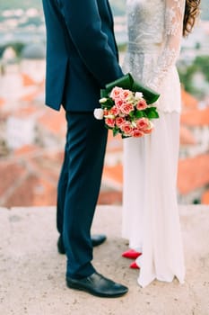 Wedding bouquet of pink roses in bride's hands. Wedding in Montenegro.