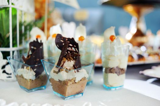 chocolate desserts in parfait cups on a white table, decor with chocolate desserts, festive table with desserts.
