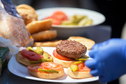 The process of making a hamburger. Hamburger bun with tomato and cutlet.