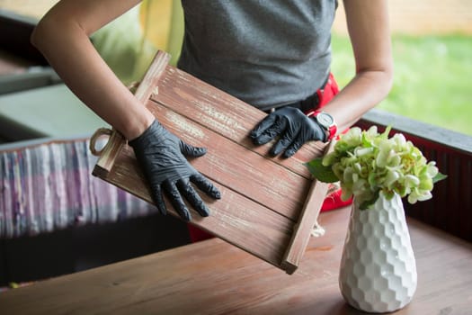 Gloved hands hold a tray in a restaurant.