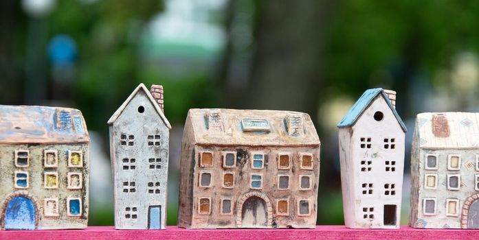 Small toy houses on a background of greenery. Toy street.
