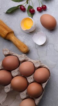 Ingredients for baking eggs rolling pin berries on a gray background. Cookie pie or cake recipe mockup. Preparing for culinary baking.