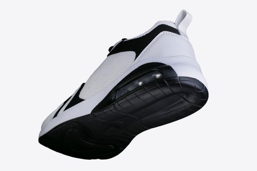 White sneaker with black accents on a black sole. Sport shoes.