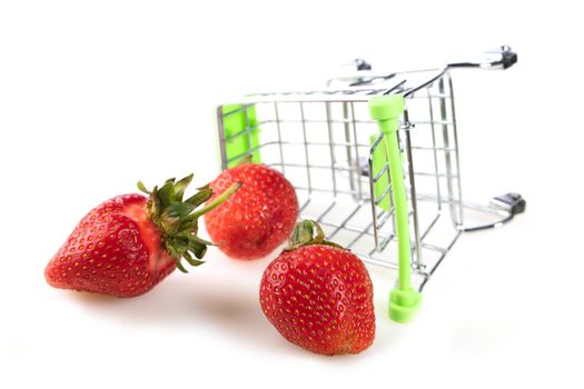 Mini supermarket trolley with scattered strawberries.Fruit sale concept.