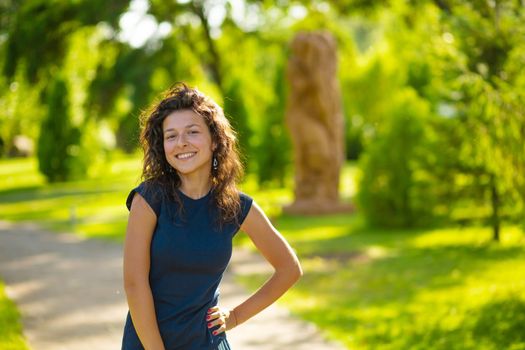 Portrait of young beautiful brunette enjoy bright summer day in green park.