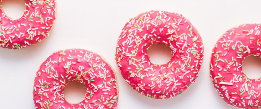 Bakery, branding and cafe concept - Frosted sprinkled donuts, sweet pastry dessert on marble table background, doughnuts as tasty snack, top view food brand flat lay for blog, menu or cookbook design