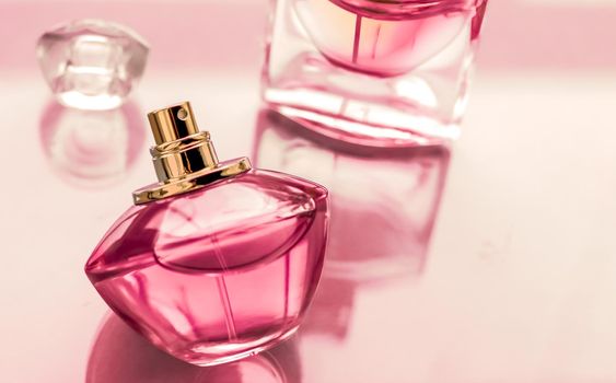 Perfumery, spa and branding concept - Pink perfume bottle on glossy background, sweet floral scent, glamour fragrance and eau de parfum as holiday gift and luxury beauty cosmetics brand design