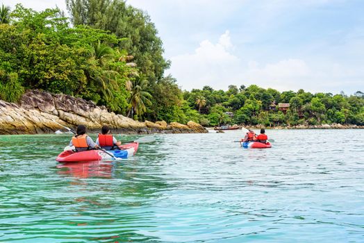 Tourist group are kayaking on the sea, travel by boat to see the beautiful nature landscape in the morning of summer at front the resort around Ko Lipe island, Tarutao National Park, Satun, Thailand