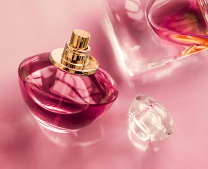 Perfumery, spa and branding concept - Pink perfume bottle on glossy background, sweet floral scent, glamour fragrance and eau de parfum as holiday gift and luxury beauty cosmetics brand design