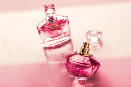 Perfumery, spa and branding concept - Pink perfume bottle on glossy background, sweet floral scent, glamour fragrance and eau de parfum as holiday gift and luxury beauty cosmetics brand design