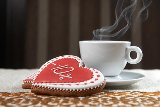 Emotional things. Morning steaming cup of coffee with a glazed gingerbread cookie with percentage written on