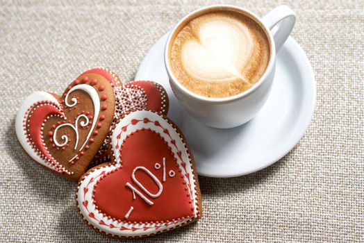 Love potion. High angle shot of a cup of frothed coffee and Valentine s day heart shaped cookies on the cafe table