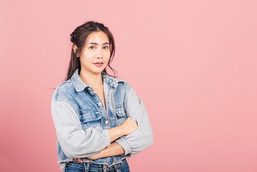Asian happy portrait beautiful cute young woman wear denim standing her smile confidence with crossed arms isolated, studio shot on pink background and copy space, Thai female looking to camera