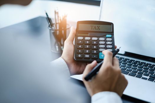 A man calculates taxes with a calculator