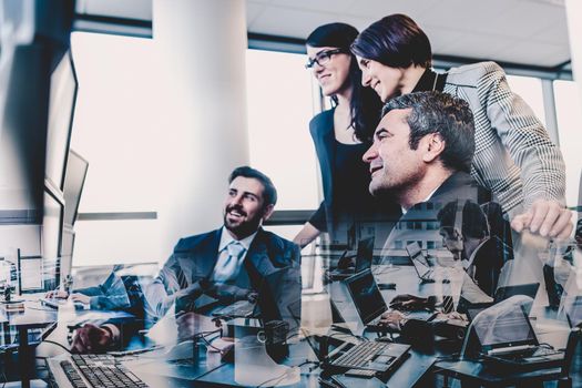 Business team looking at data on multiple computer screens in corporate office. Business people trading online. Business, entrepreneurship and team work concept.