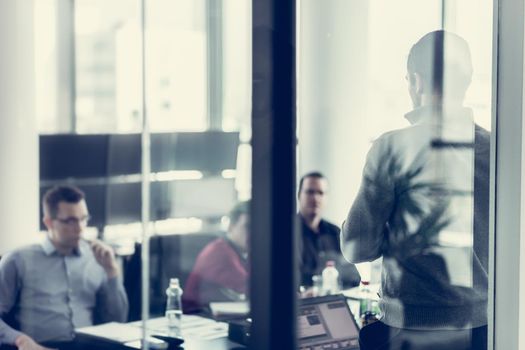 Businessman making a presentation at office. Business team leader delivering a presentation to his colleagues during meeting or in-house business training.