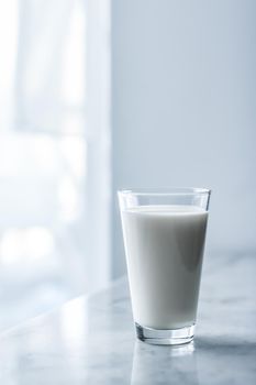 Dairy, healthy nutrition and breakfast concept - World Milk Day, full glass on marble table