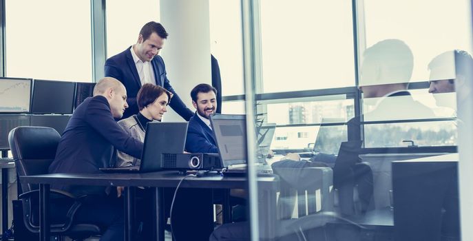 Workplace in modern office with business people brainstorming. Businessman working on laptop during the meeting.