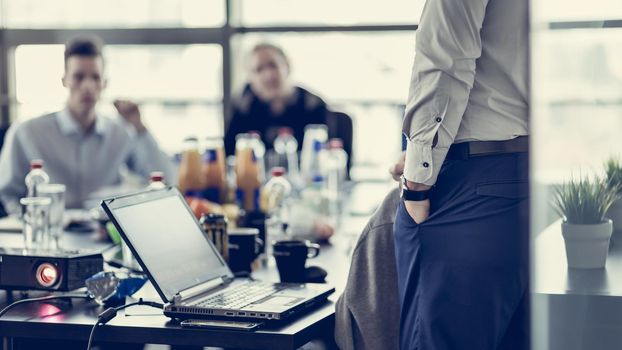 Business man making a presentation at office. Business executive delivering a presentation to his colleagues during meeting or in-house business training. Rear view. Business and entrepreneurship.