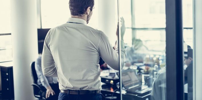 Business man making a presentation at office. Business executive delivering a presentation to his colleagues during meeting or in-house business training, explaining business plans to his employees.