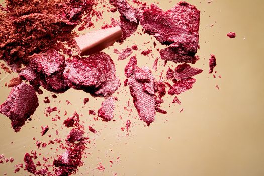 Crushed cosmetics, mineral organic eyeshadow, blush and cosmetic powder isolated on golden background, makeup and beauty banner, flatlay design.