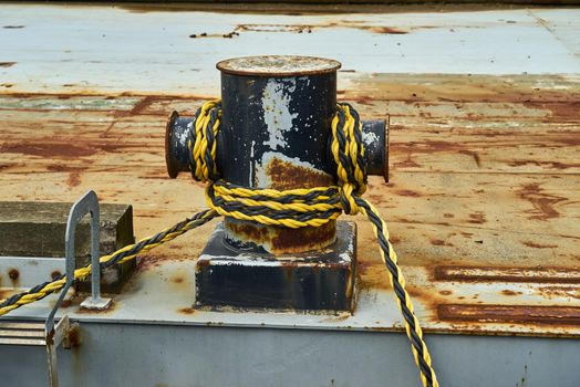 The cross shaped mooring bitt has mooring line wrapped around it to anchor a ship in while in port.