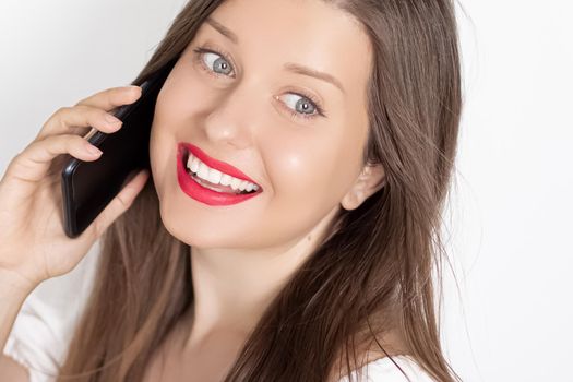 Happy smiling woman calling on smartphone, portrait on white background. People, technology and communication concept.