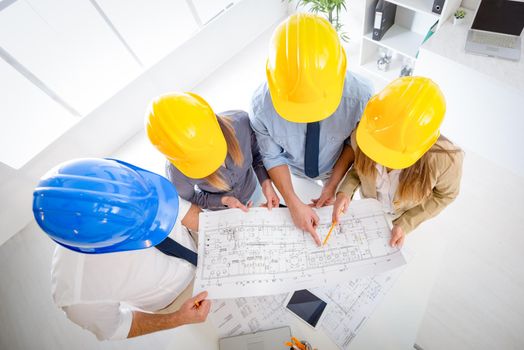 Young architect team discussing construction plans and planning what to change to be better. They are in the office. Top view.