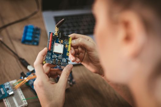 Close-up of a female hands soldering circuit board on the table.