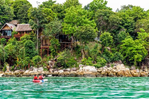 Two tourists are father and daughter travel by boat with a kayak in summer at front the resort on island of Ko Lipe enjoy the beautiful nature the sea in morning, Tarutao National Park, Satun, Thailand